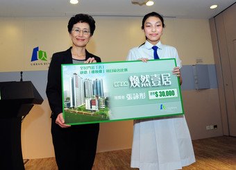 Managing Director of URA Iris Tam (left) congratulates secondary school student Cheung Wing-tung (right) for winning the Chinese naming competition for the URA's Kai Tak Flat-for-Flat development
