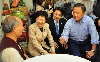 Secretary for Development, Carrie Lam, Chairman of Yau Tsim Mong District Council, Edmond Chung, and Chairman of URA, Barry Cheung, visiting an owner of the Pine Street/Oak Street project